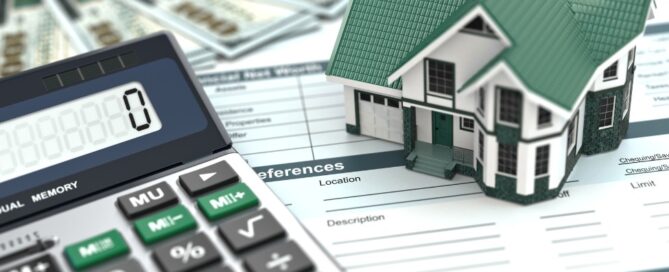 Calculator, model house on financial documents, representing home budgeting or mortgage planning, relevant to Pratt Home Builders in Chattanooga TN.