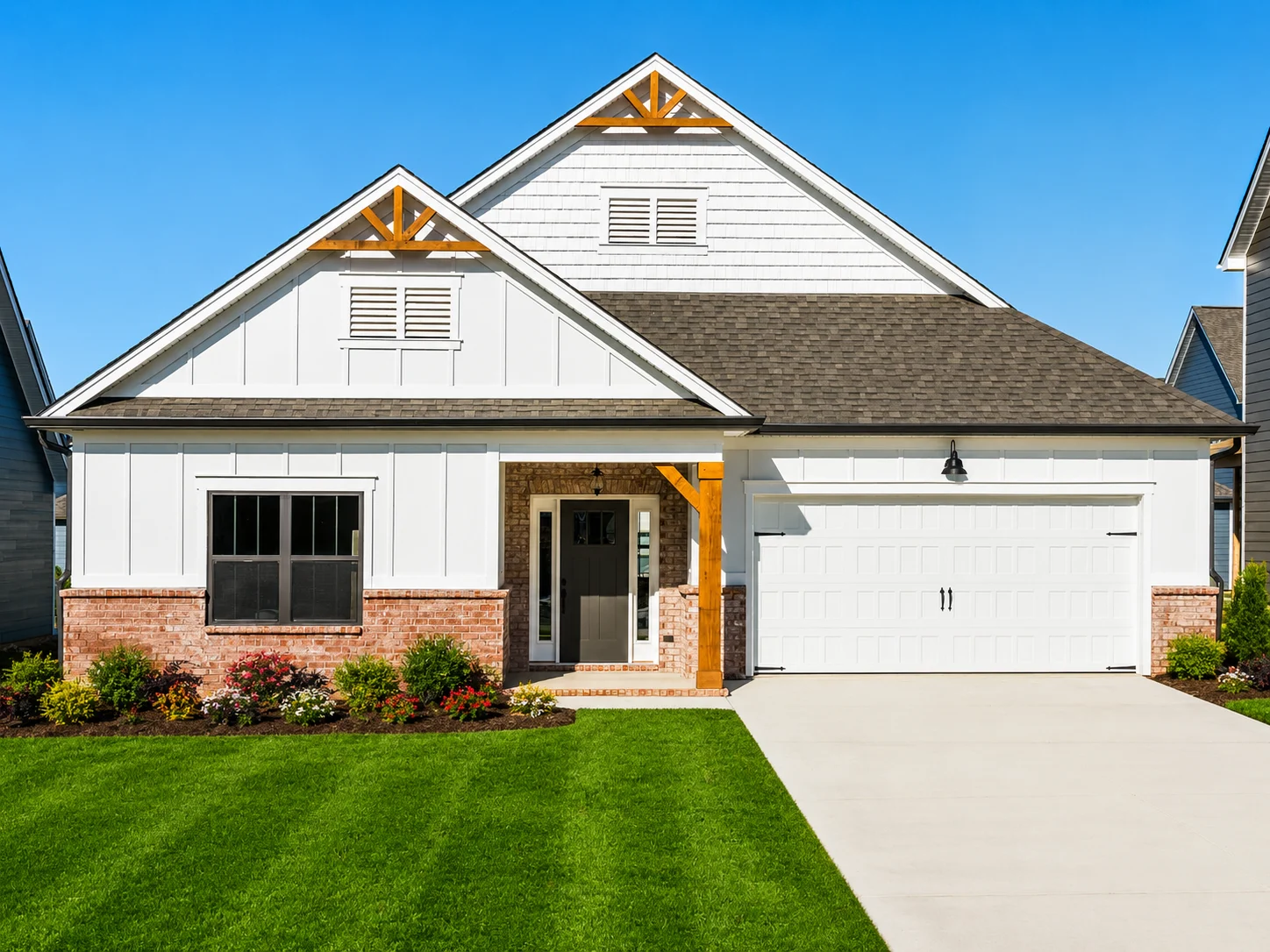 Modern white house with brick accents, gable roof, and lush green lawn, built by Pratt Home Builders in Chattanooga TN.