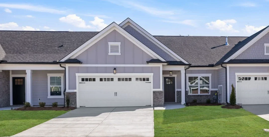 Iris (1) Modern suburban home with a gray facade, double garage, and neatly landscaped lawn. Built by Pratt Home Builders in Chattanooga TN.