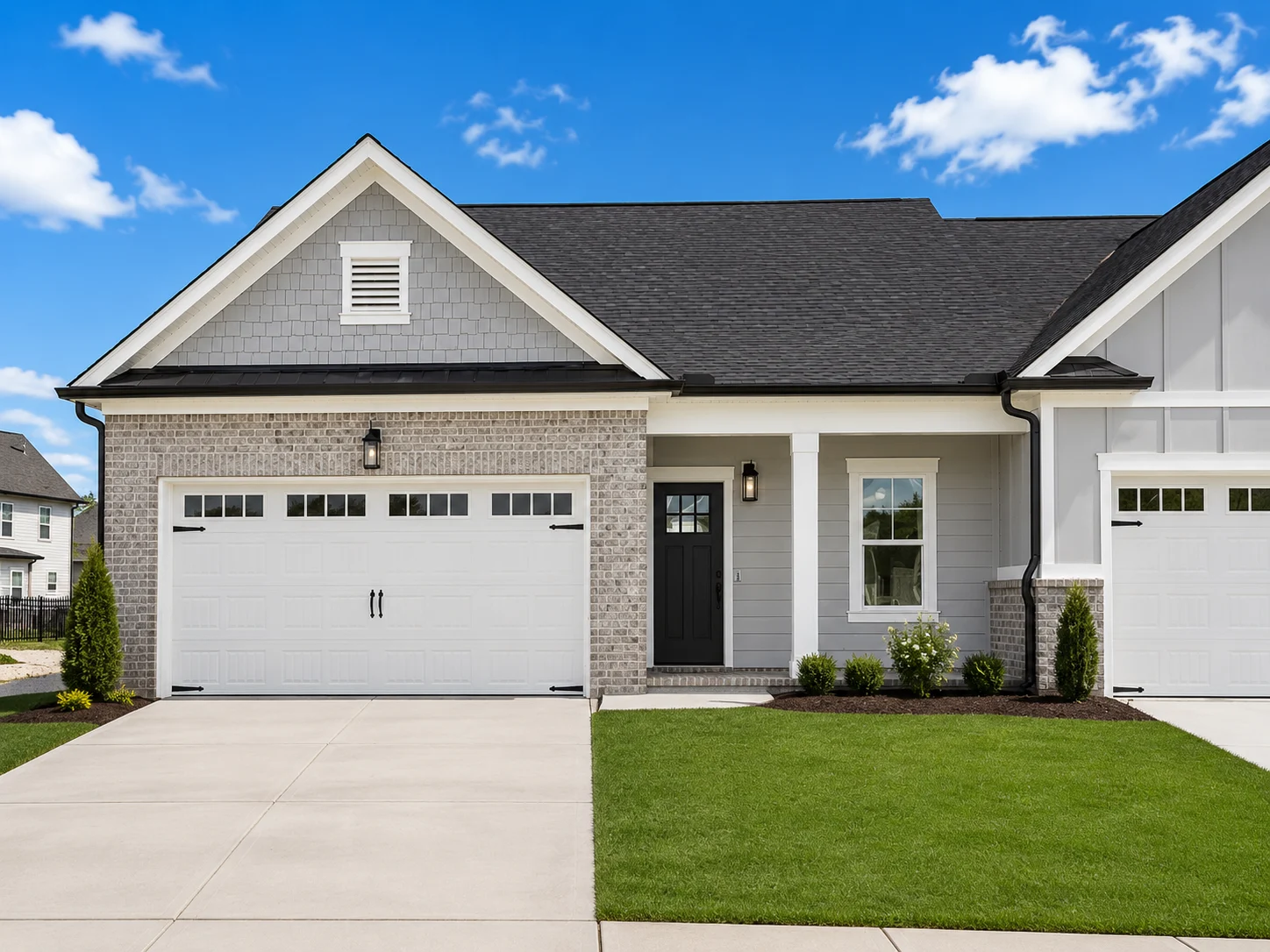 Charming modern home by Pratt Home Builders in Chattanooga, TN, featuring a sleek garage, well-kept lawn, and gray brick exterior.