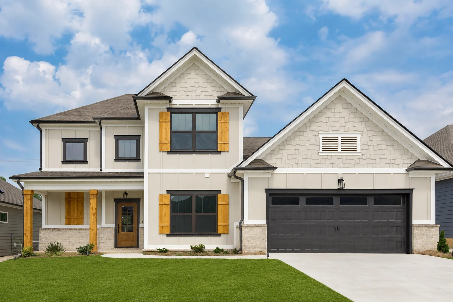 Two-story house with wooden shutters and black garage door. Built by Pratt Home Builders in Chattanooga TN.
