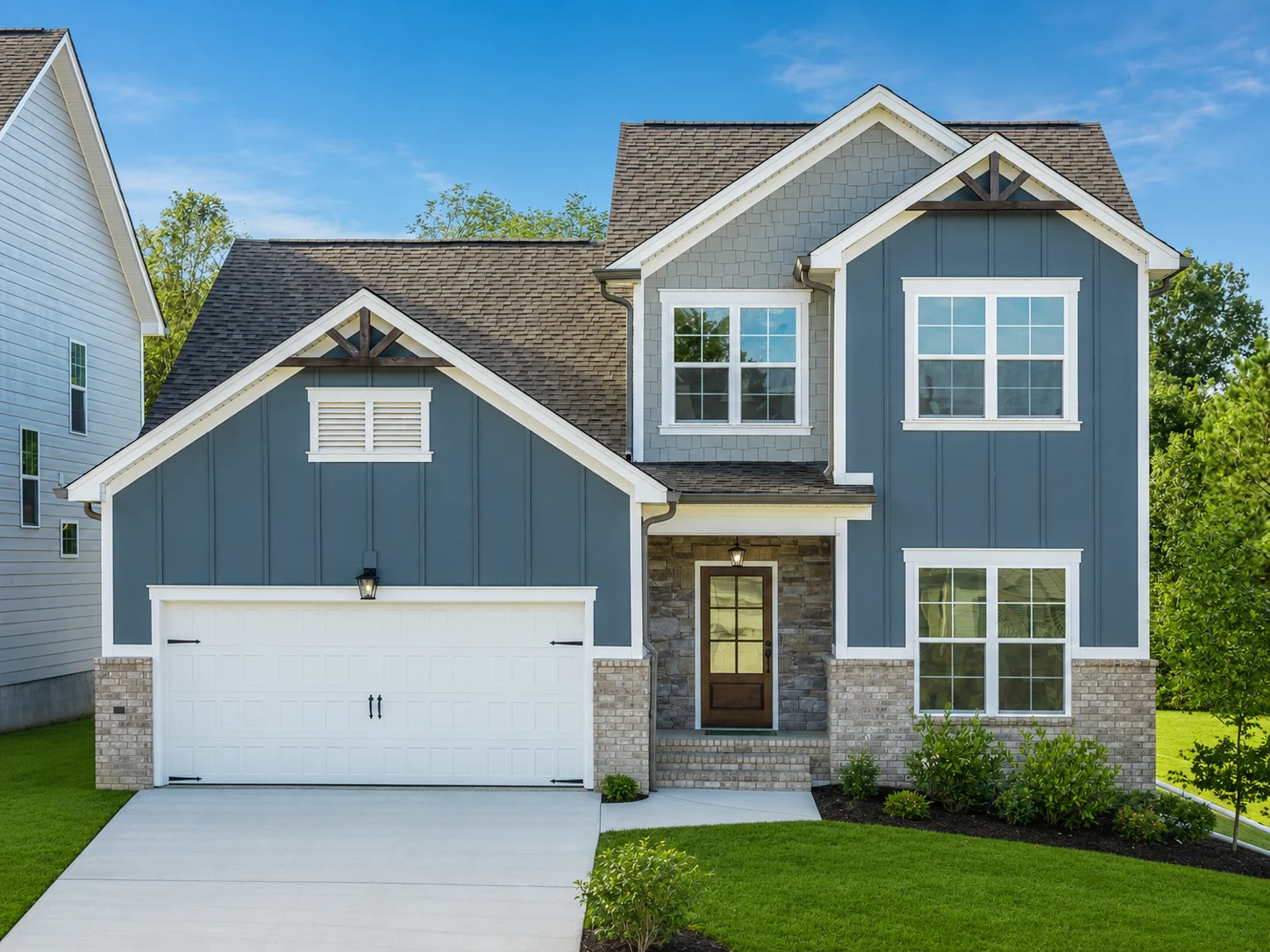 Two-story modern house with gray siding, white trim, and a garage, built by Pratt Home Builders in Chattanooga TN. Lush green lawn in front.