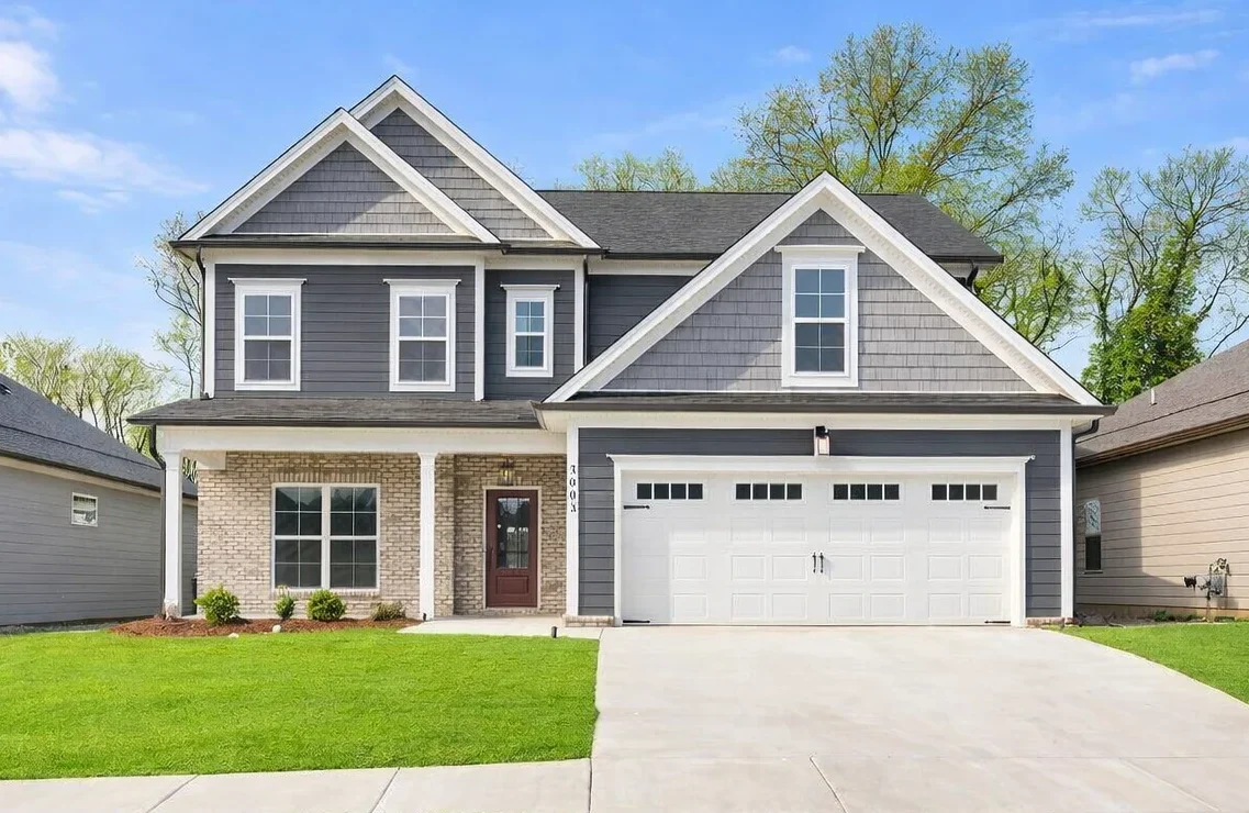 New Home Chattanooga TN. Gray two-story house with white accents, two-car garage, and manicured lawn by Pratt Home Builders.