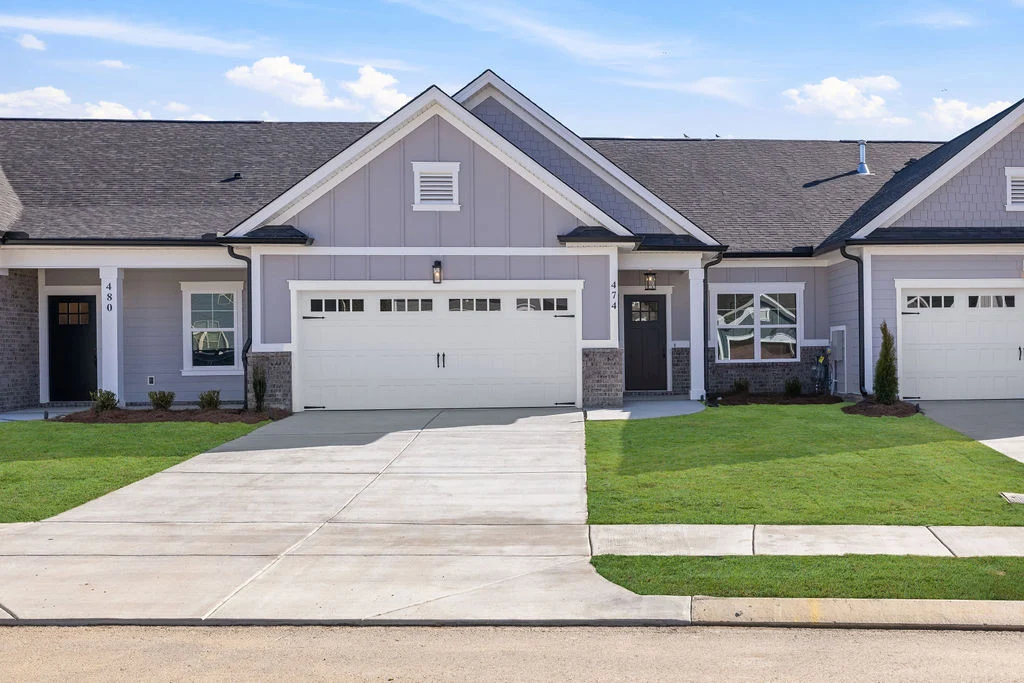 New Home Chattanooga TN. Gray row townhome with white trim, two garage doors, and manicured lawn. Built by Pratt Home Builders.