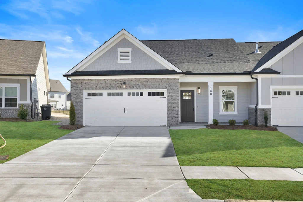 New Home Chattanooga TN. Modern suburban townhome with gray bricks and white accents, featuring a double garage. Built by Pratt Home Builders