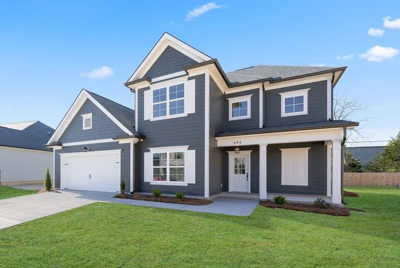 New Home Chattanooga TN. Two-story dark gray house with white trim by Pratt Home Builders featuring a front porch and integrated garage.