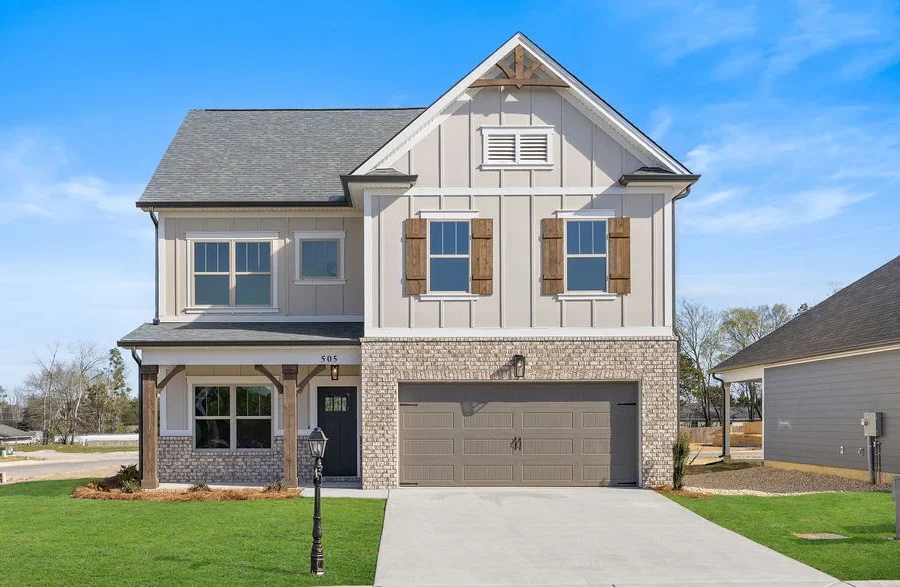 New home Chattanooga TN. Two-story house with brick and siding exterior, double garage, and manicured lawn by Pratt Home Builders.