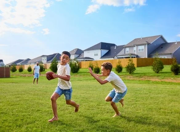 Kids playing football in Pratt Home Builders Community