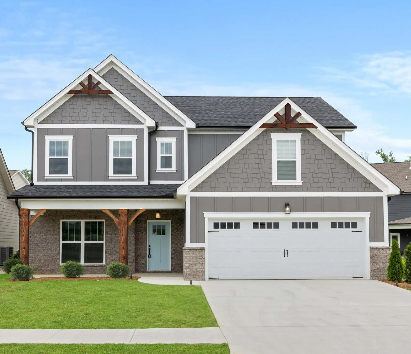 New Home Chattanooga TN. Modern two-story home with gray siding, white trim, and arched wooden accents, built by Pratt Home Builders.
