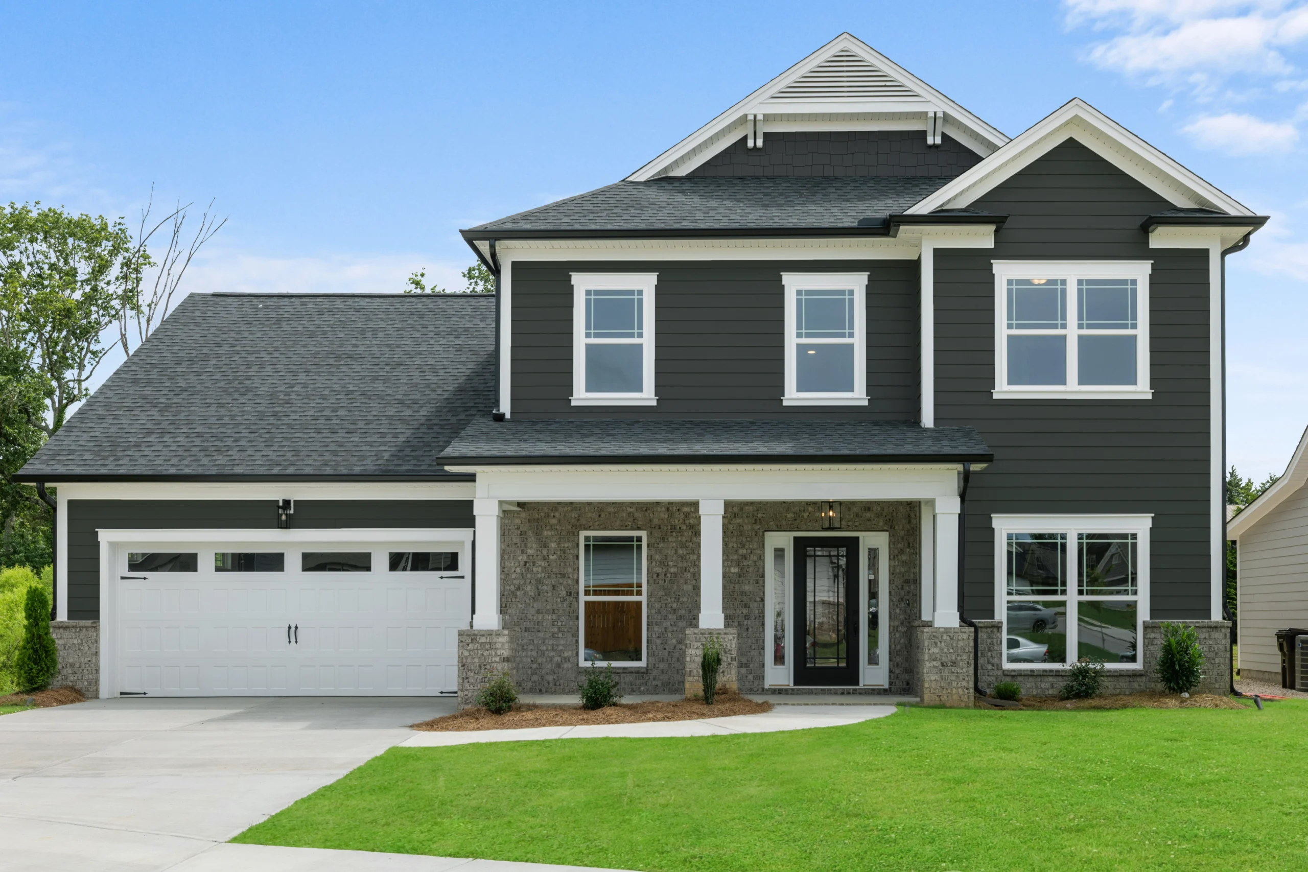 New Home Chattanooga TN. Two-story modern house with dark siding, white trim, and a spacious garage, built by Pratt Home Builders.