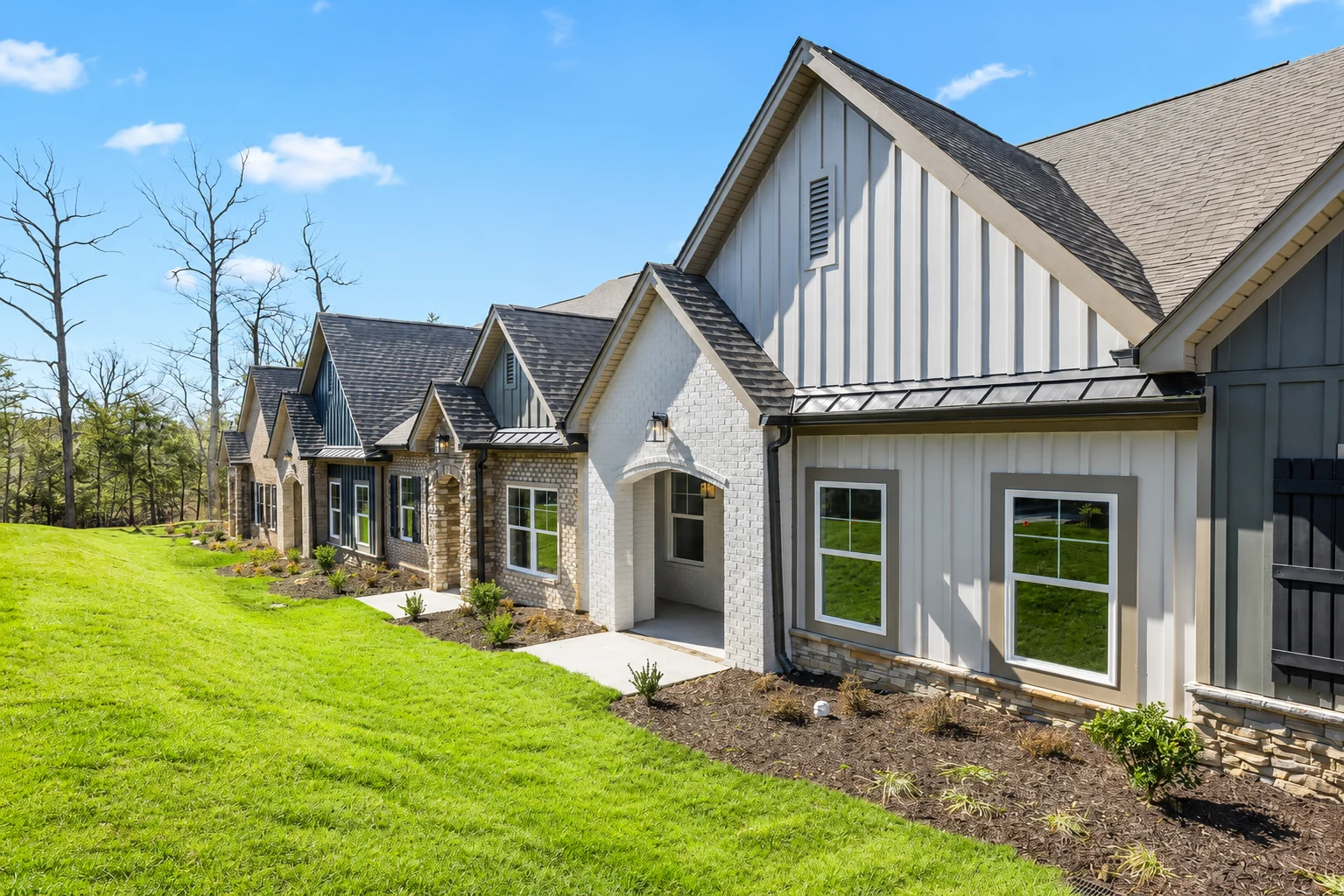 Modern ranch-style home with stone and white siding, landscaped yard. Built by Pratt Home Builders in Chattanooga TN.