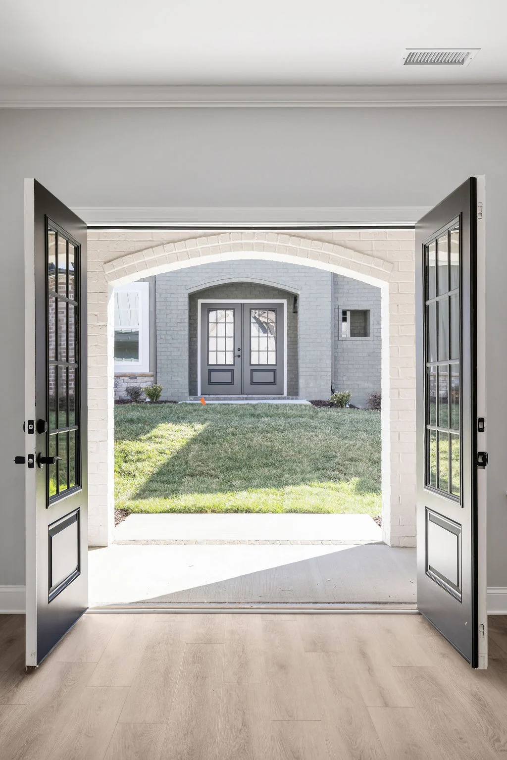 New Home Chattanooga TN. Open double doors reveal a lawn and another set of glass-panel doors; designed by Pratt Home Builders.