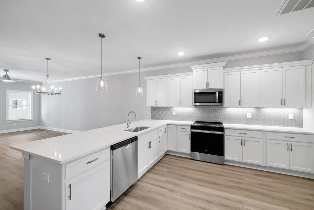 New Home Chattanooga TN. Modern kitchen by Pratt Home Builders, featuring white cabinets, stainless appliances, island, and light fixtures.