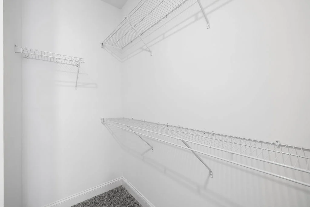 White walk-in closet with wire shelving and carpeted floor, designed by Pratt Home Builders in Chattanooga TN.