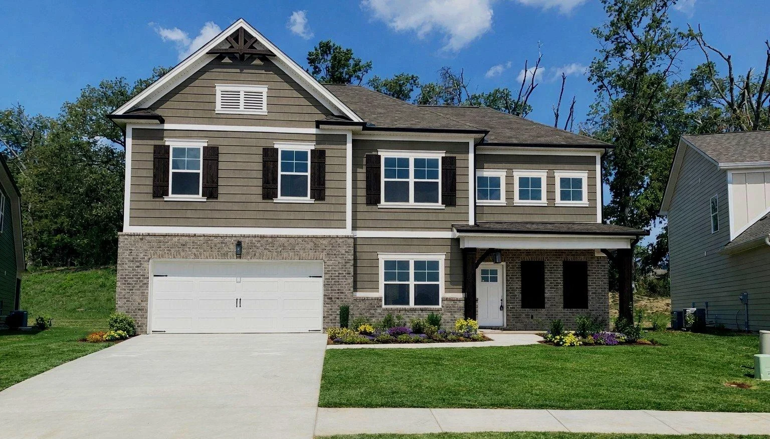 New Home Chattanooga TN. Two-story house with brown siding, white trim, landscaped front yard, and double garage. By Pratt Home Builders.