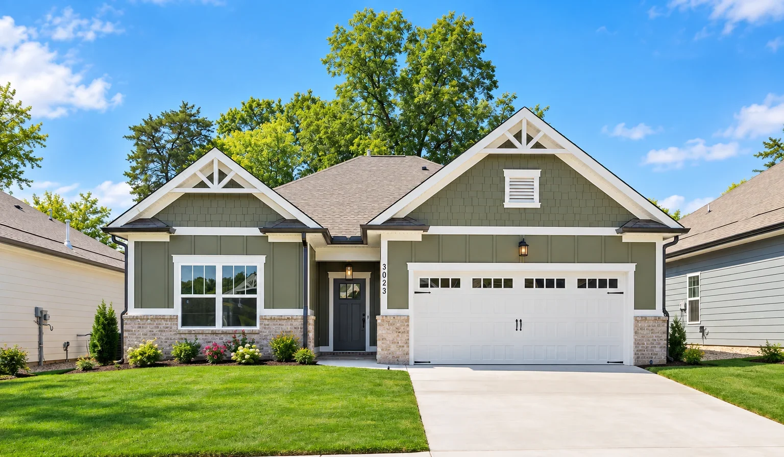 Modern single-story home with green siding, white trim, and a two-car garage, built by Pratt Home Builders in Chattanooga TN.