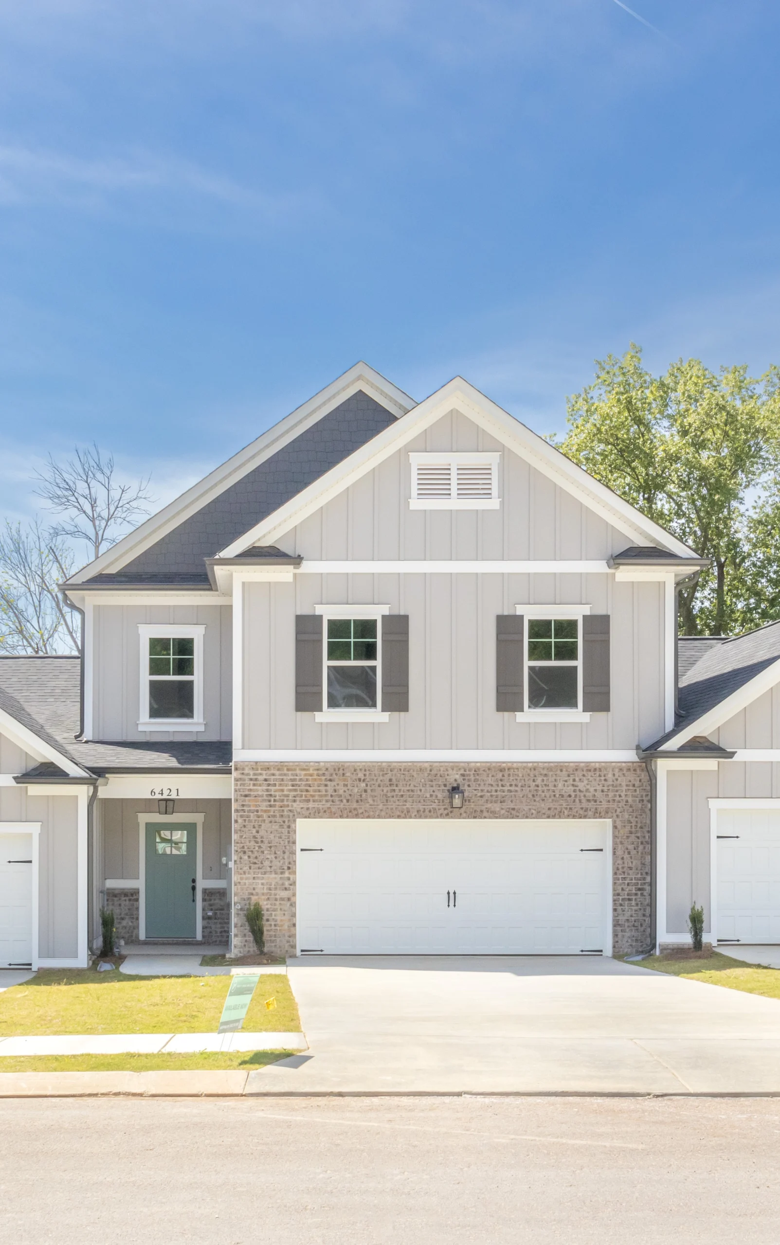 Two-story house with brick and siding facade, double garage, and a light blue door. Built by Pratt Home Builders in Chattanooga TN.