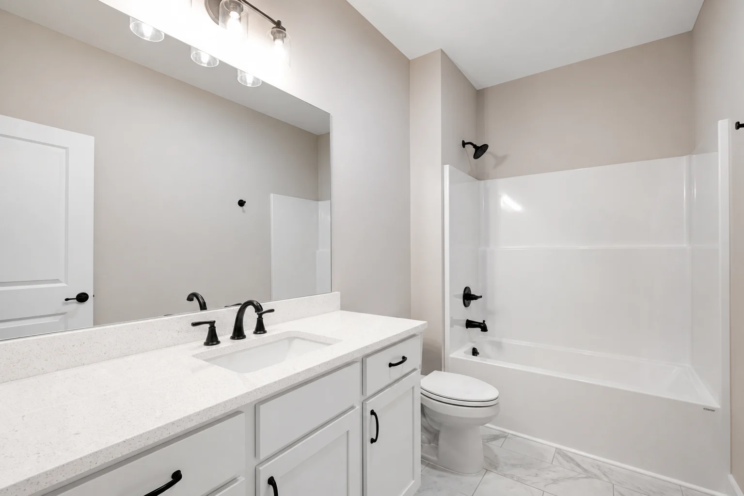 Modern bathroom with white cabinets, black fixtures, and a tub, designed by Pratt Home Builders in Chattanooga TN.