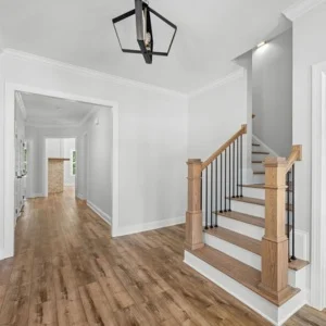 Entryway Bright hallway with wooden floors, modern staircase, and black pendant light. Crafted by Pratt Home Builders in Chattanooga TN.