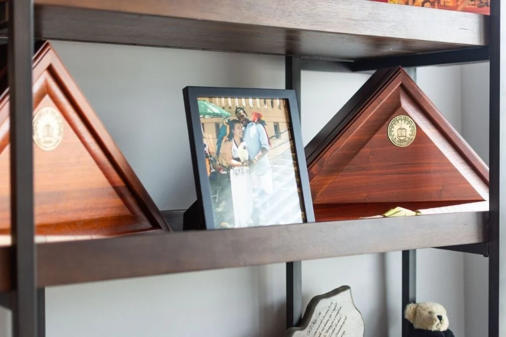 Pratt LOVES Their Veterans Your Path to a New Home Starts Here (1) Wooden shelves displaying military flag cases and a framed photo, associated with Pratt Home Builders in Chattanooga TN.