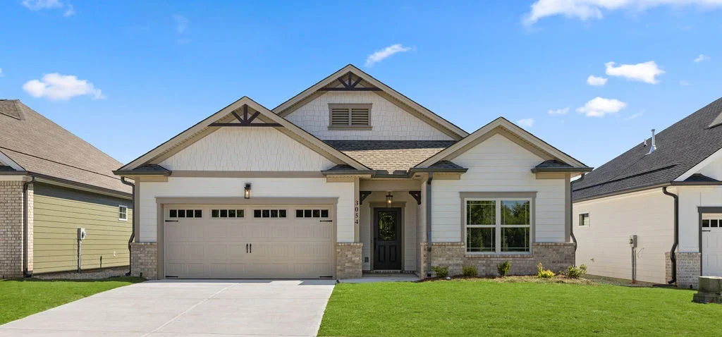 Modern single-story house with a two-car garage, manicured lawn, and neutral tones by Pratt Home Builders in Chattanooga TN.