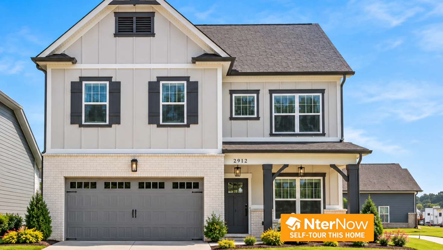 Two-story house with a gray garage, white siding, and dark shutters. NterNow tour sign. Built by Pratt Home Builders in Chattanooga TN.