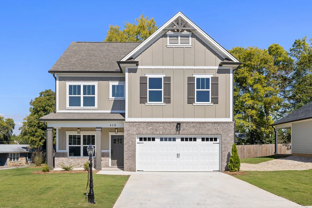 Modern two-story home with a gray and beige facade, garage, and manicured lawn. Built by Pratt Home Builders in Chattanooga TN.