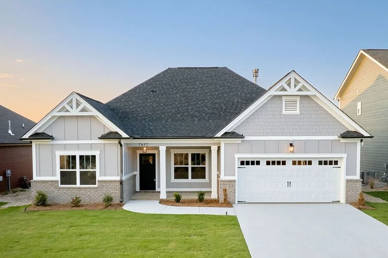 Modern single-story home with garage and manicured lawn by Pratt Home Builders in Chattanooga TN, under a clear blue sky.