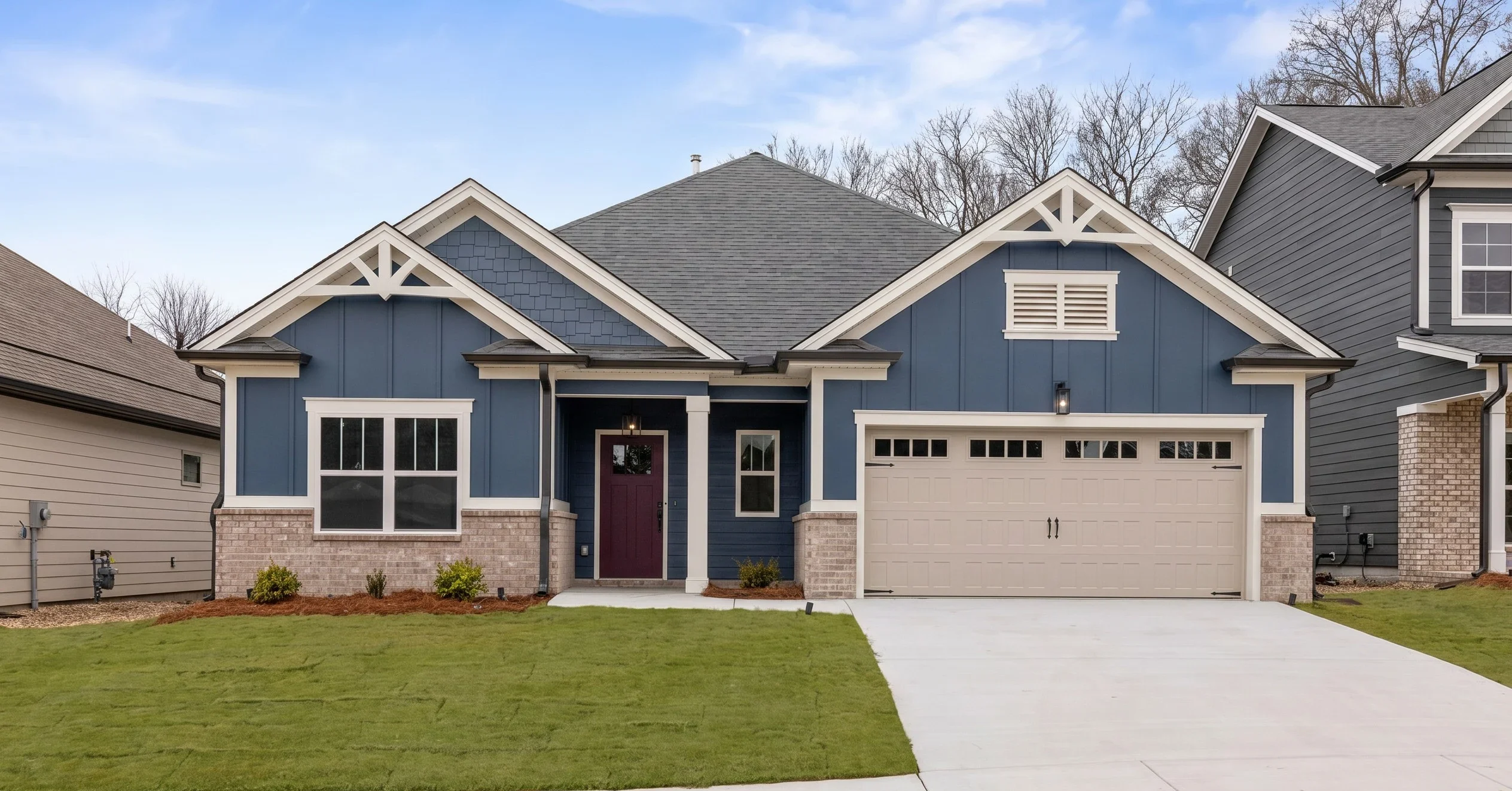 Modern blue house with gray roof, two-car garage, and neat lawn, built by Pratt Home Builders in Chattanooga TN.