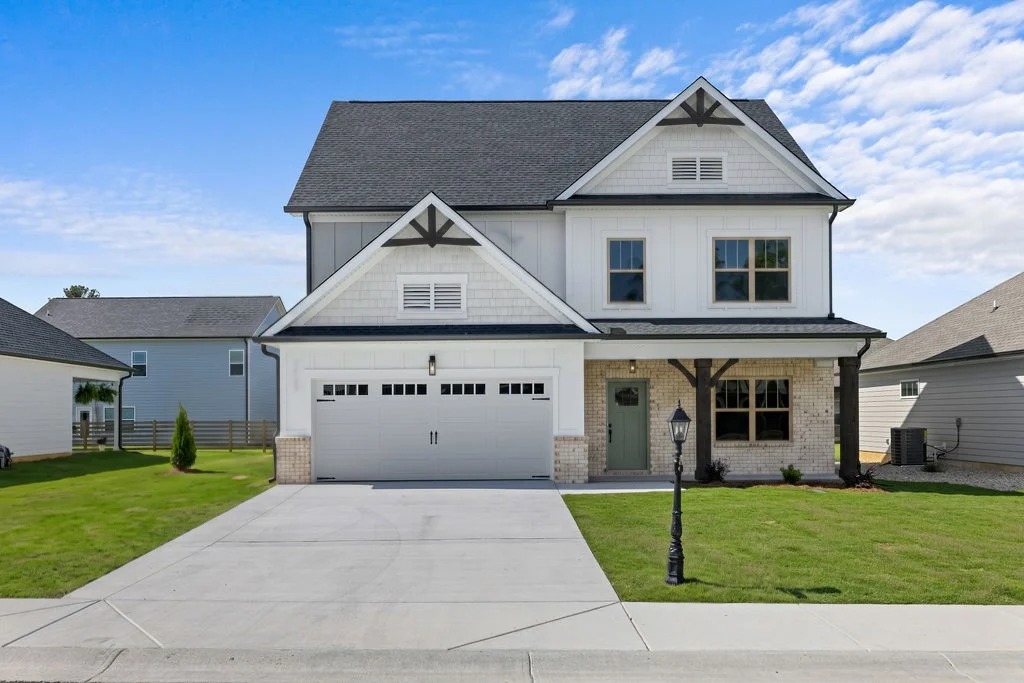 Modern two-story home with brick and siding facade, spacious driveway, by Pratt Home Builders in Chattanooga, TN.