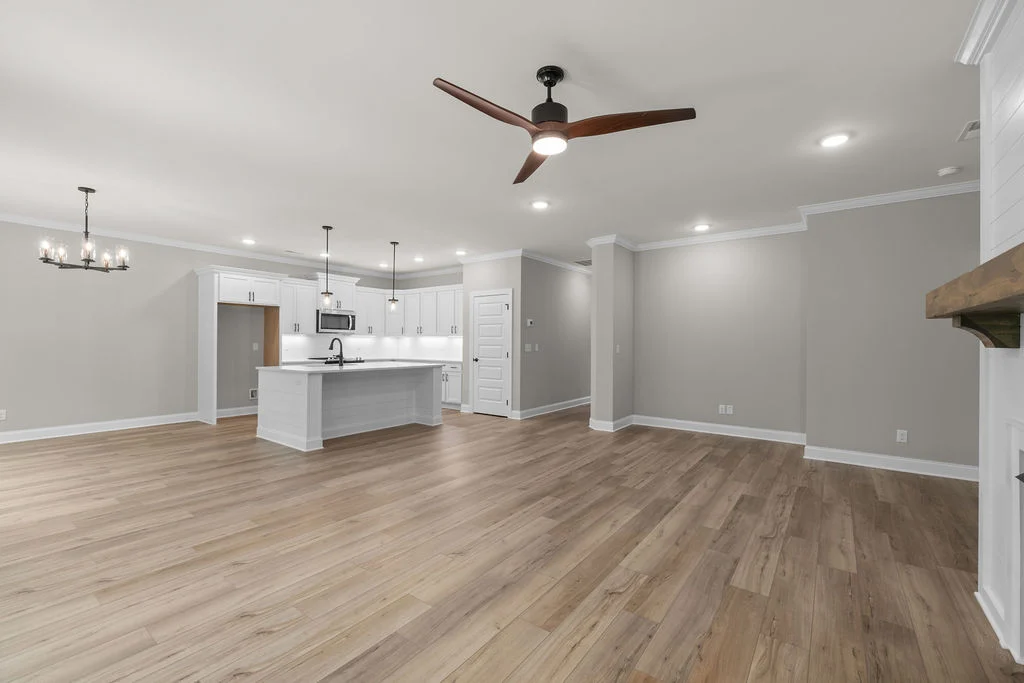 Spacious open-concept kitchen and living area with hardwood floors and modern fixtures, designed by Pratt Home Builders in Chattanooga TN.